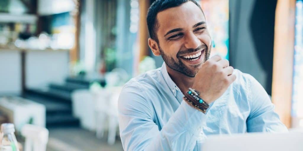 A smiling man mastering these life-changing positive habits