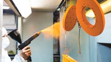 worker usng a powder coating sprayer